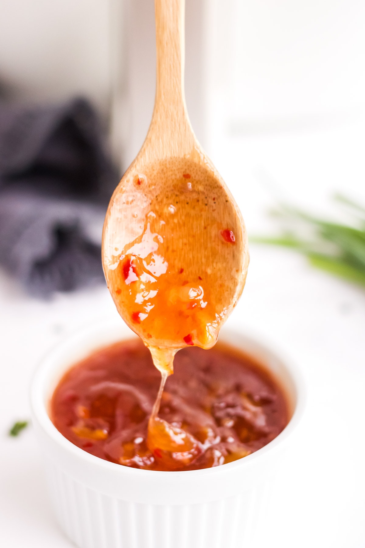 thai chili sauce, white bowl, wooden spoon