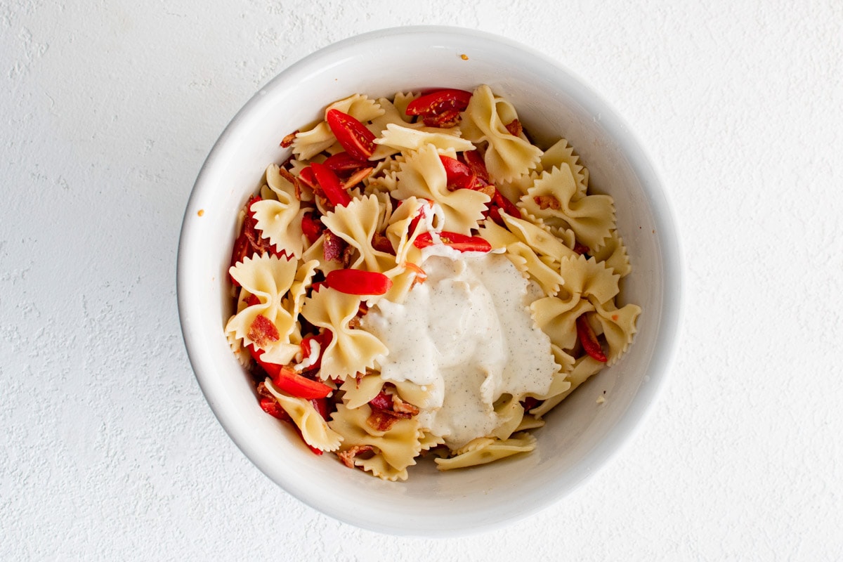 Pasta, tomatoes and bacon in a bowl.