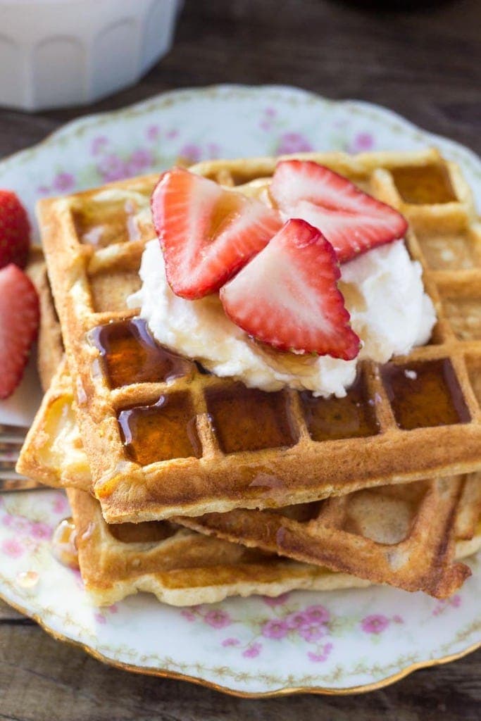 homemade waffles with syrup and whipped crea and strawberries