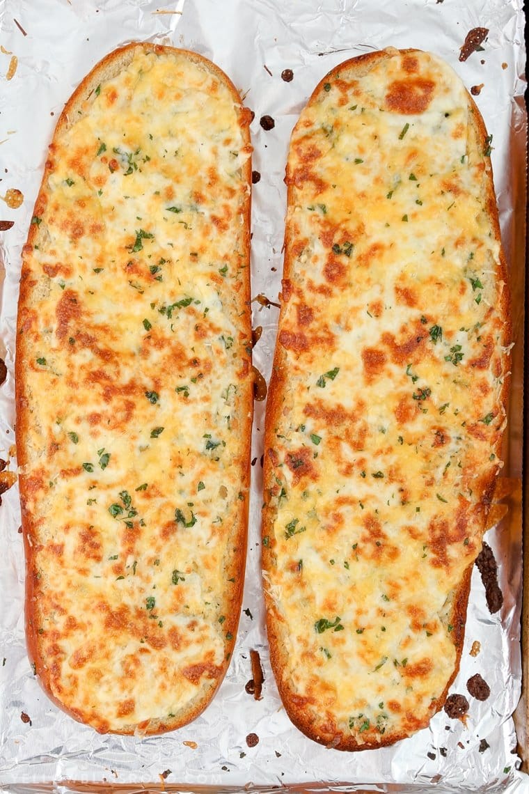 Two halves of cheesy garlic bread - homemade garlic bread with golden browned cheese.