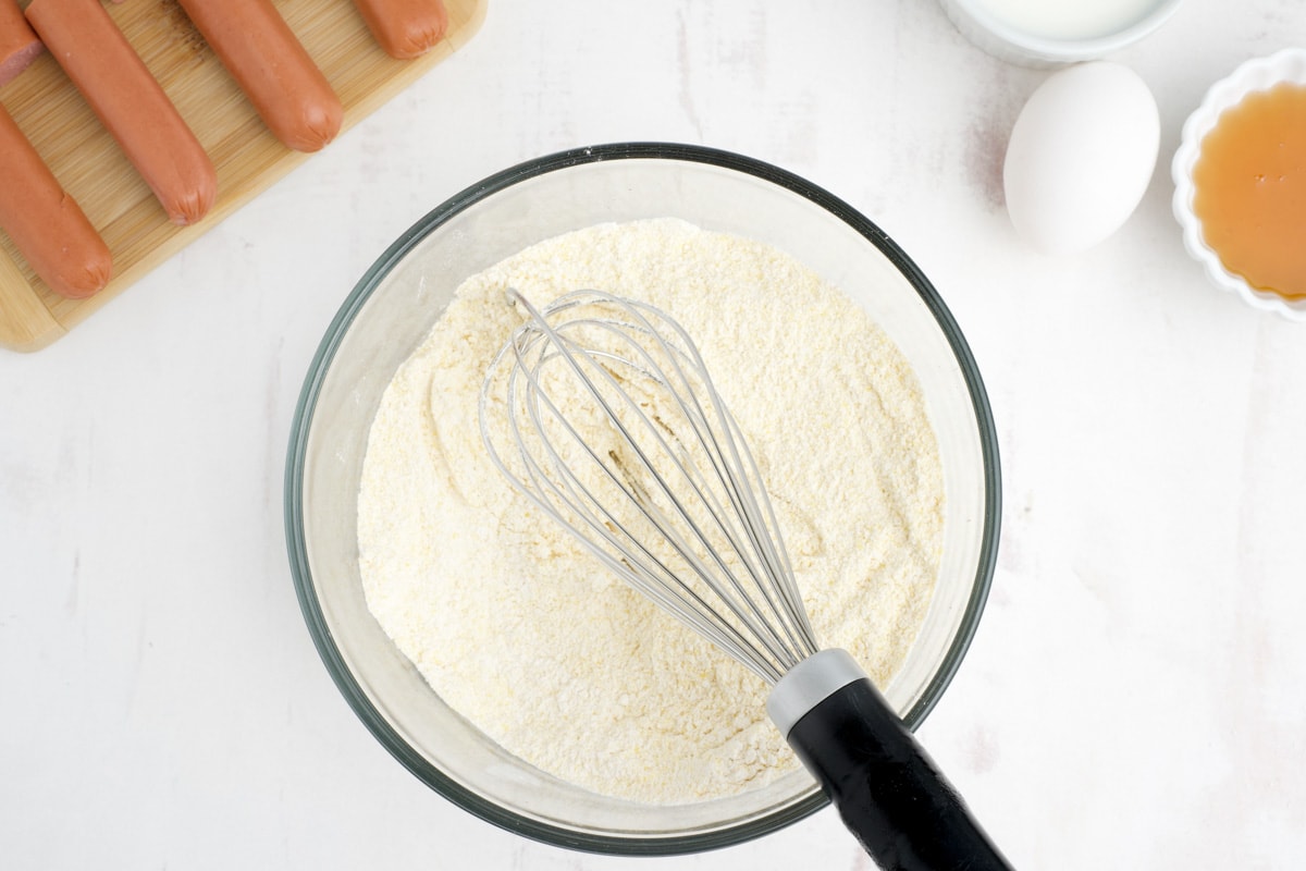 A whisk in a bowl of batter.