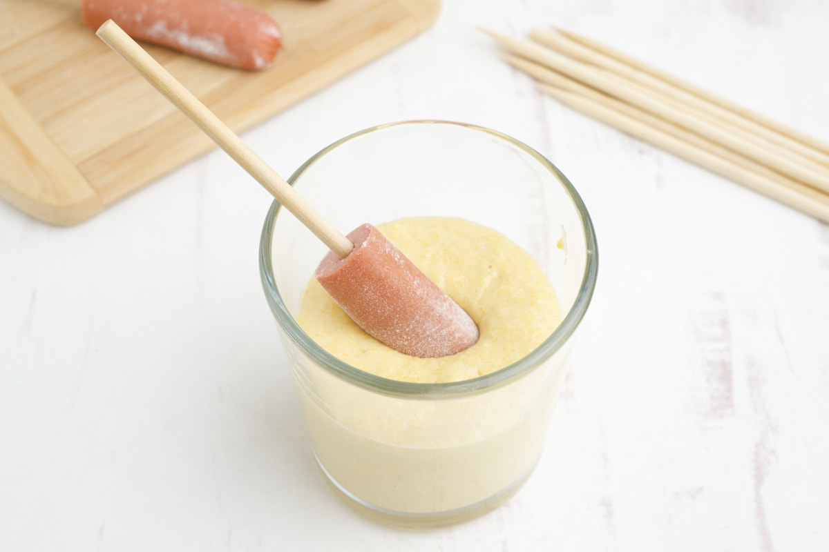 Hot dog on a stick dipped in corn dog batter.