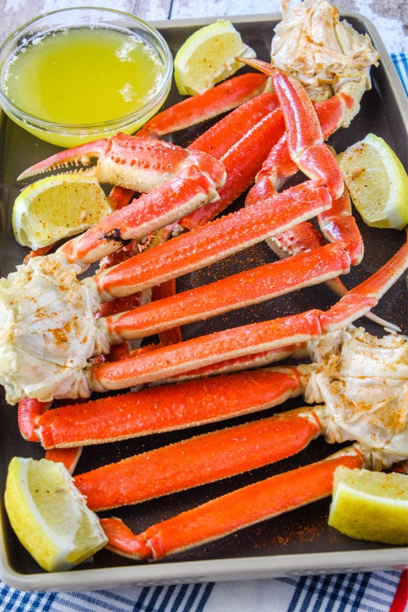 snow crab clusters on a plate with lemon wedges and melted butter