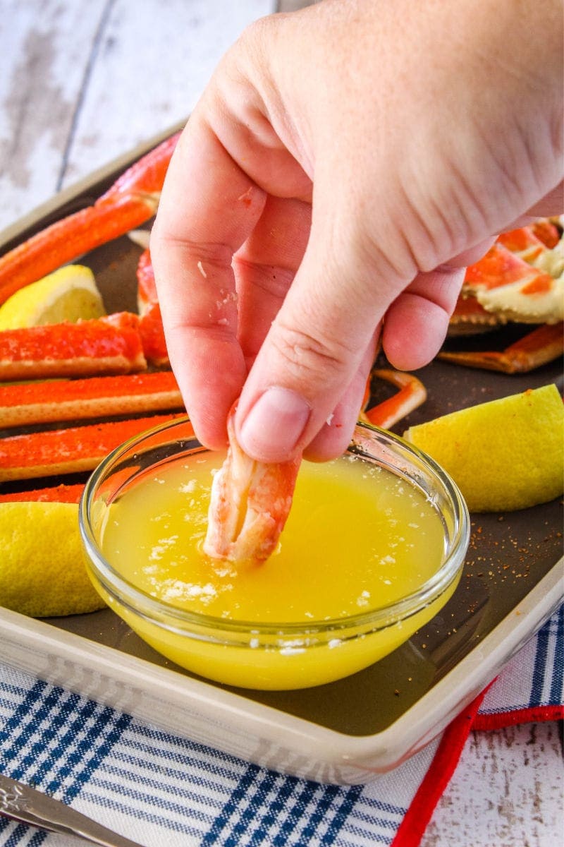 piece of crab meat being dipped into melted butter
