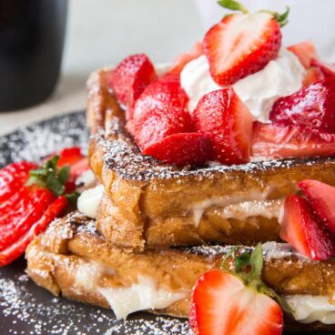 Plate of Cream Cheese Stuffed French Toast with Strawberries on top.