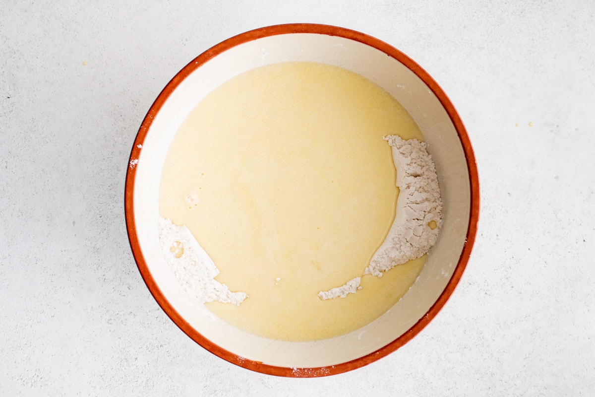 Yellow liquid and white powder in a mixing bowl.