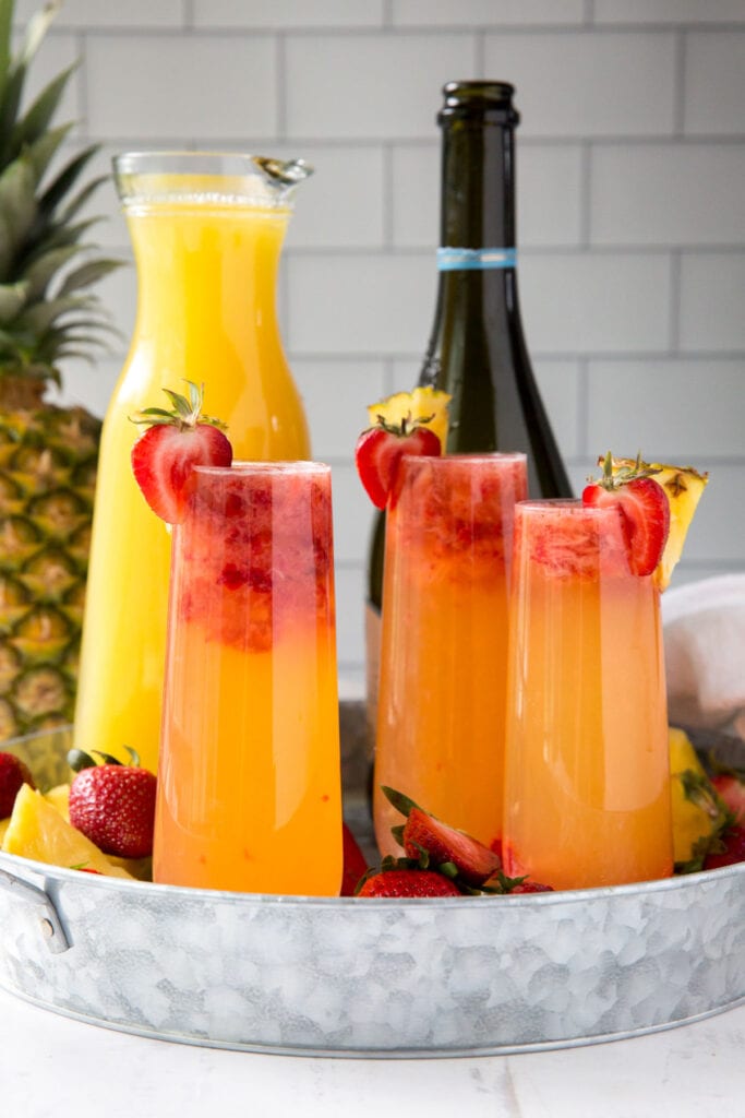 galvanized tray, champagne flutes with pineaple strawberry mimosas, champagne