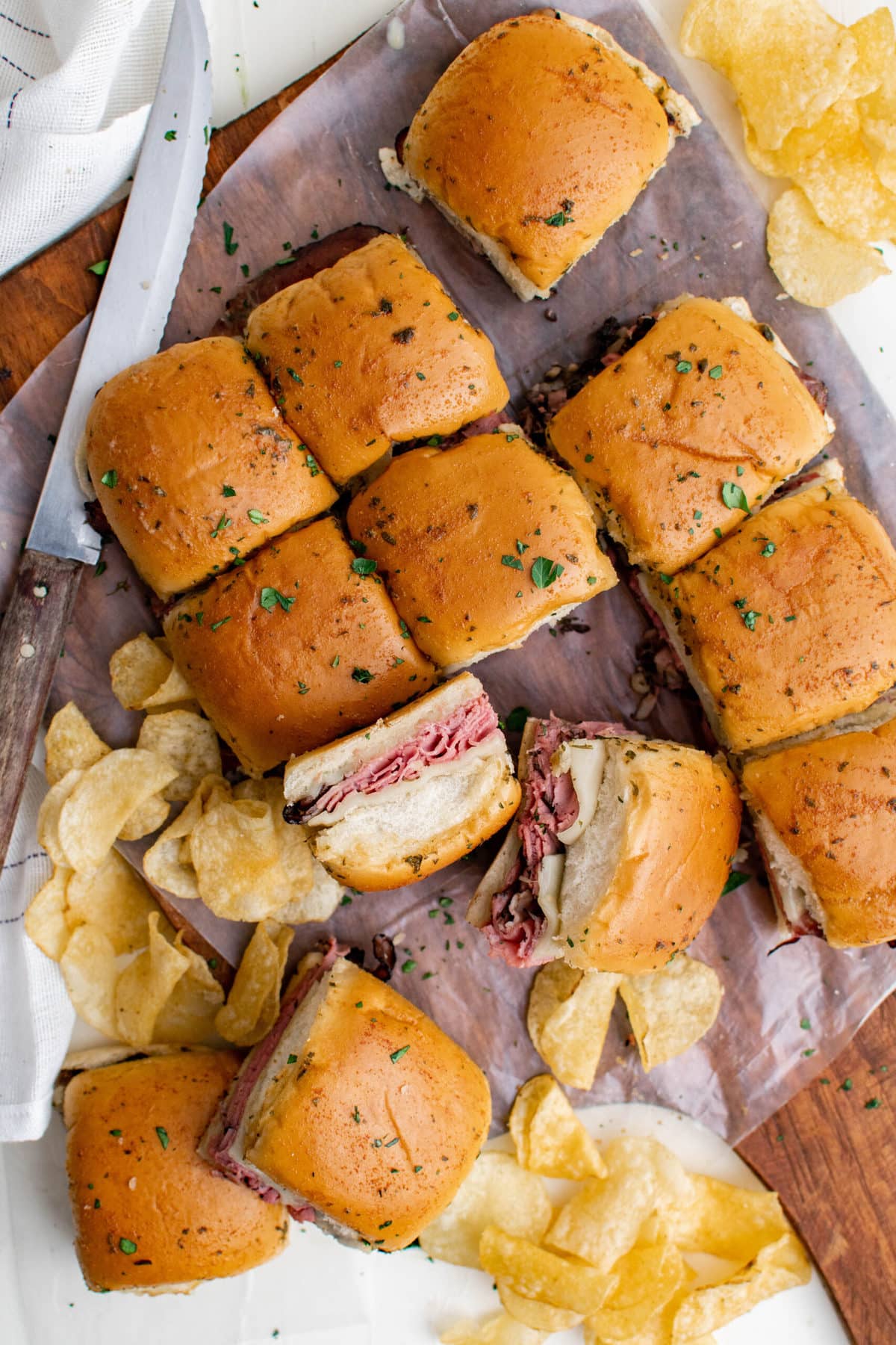 wood background, a dozen roast beef and cheese sliders, potato chips