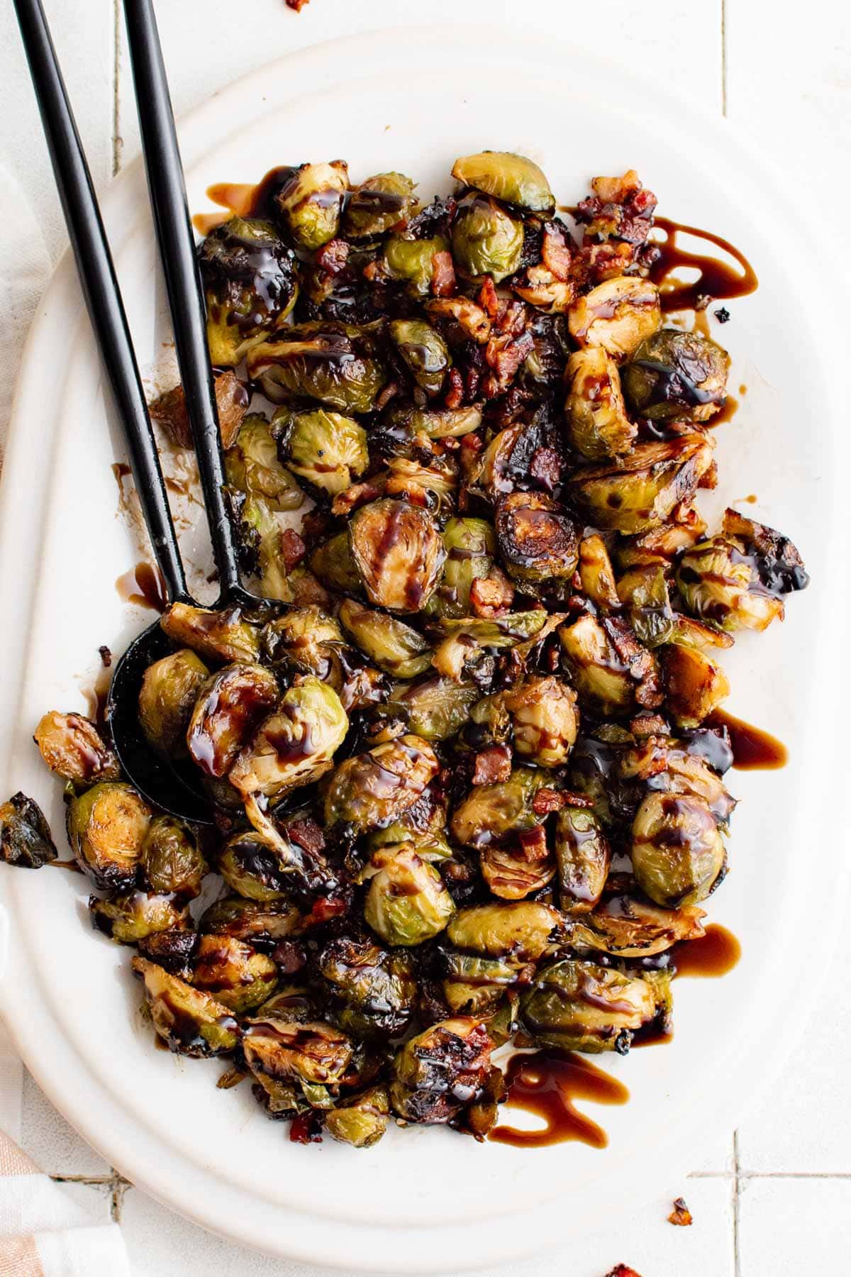 Large platter with balsamic drizzle over roasted brussels sprouts.
