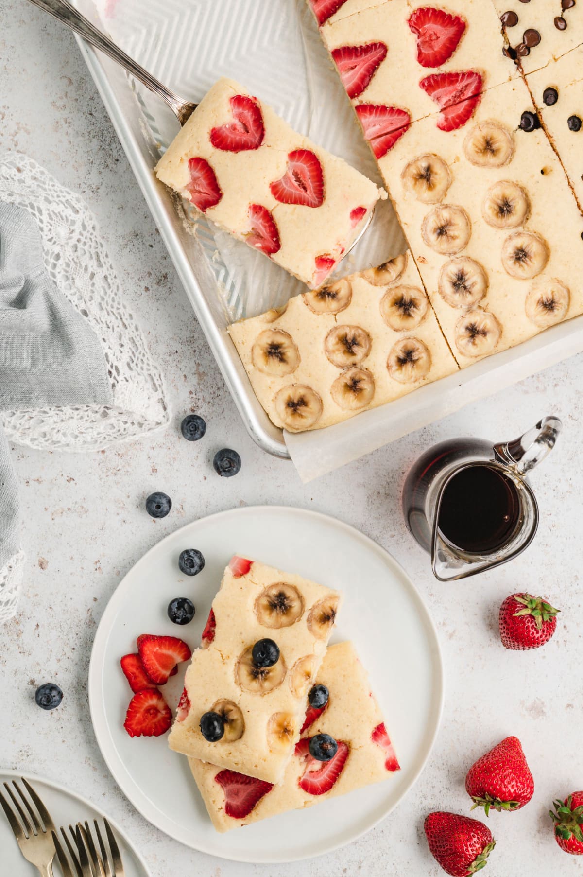 Pancake with strawberries on a small plate and in a sheet pan. 