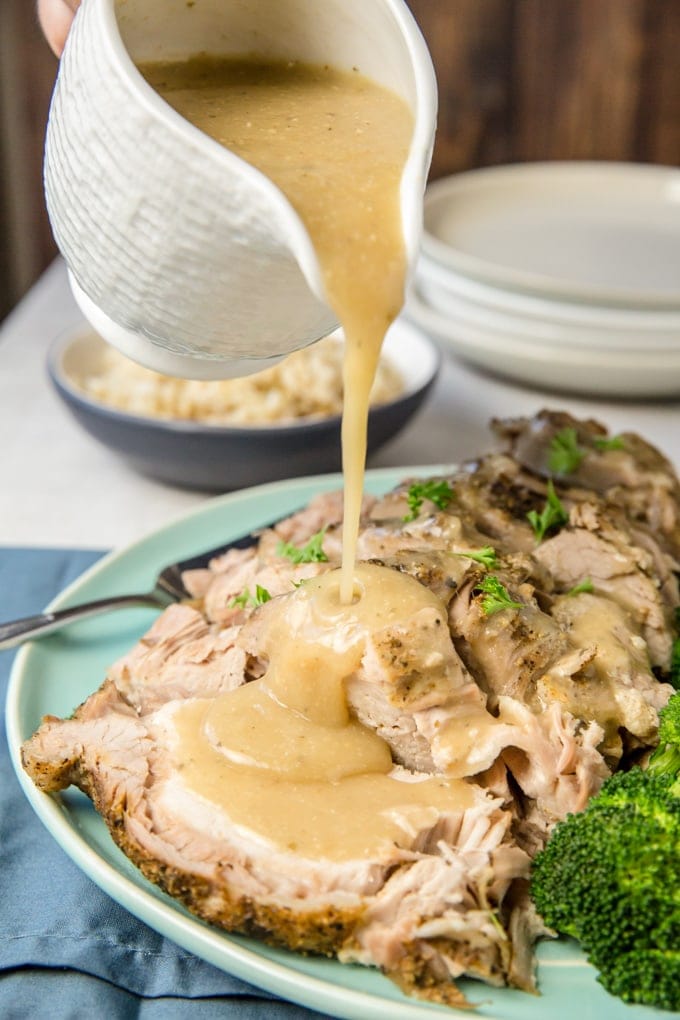 Crock Pot Pork Roast with gravy being poured on it.