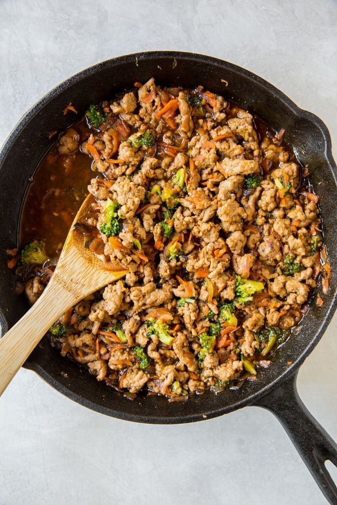 Cooked ground turkey recipe in a skillet with vegetables and teriyaki sauce. Cast iron skillet.
