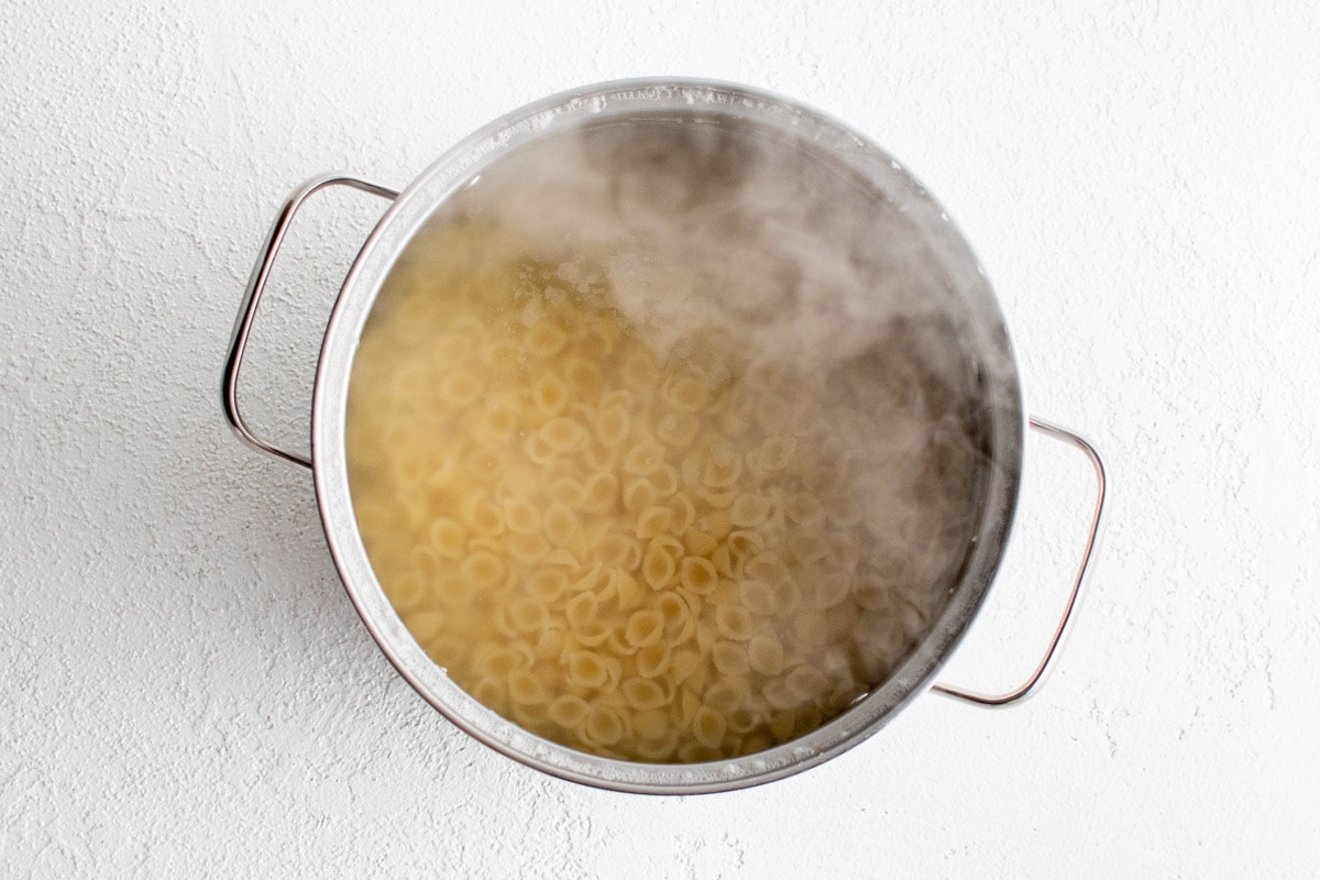 Pasta cooking in boiling water in a large pot.