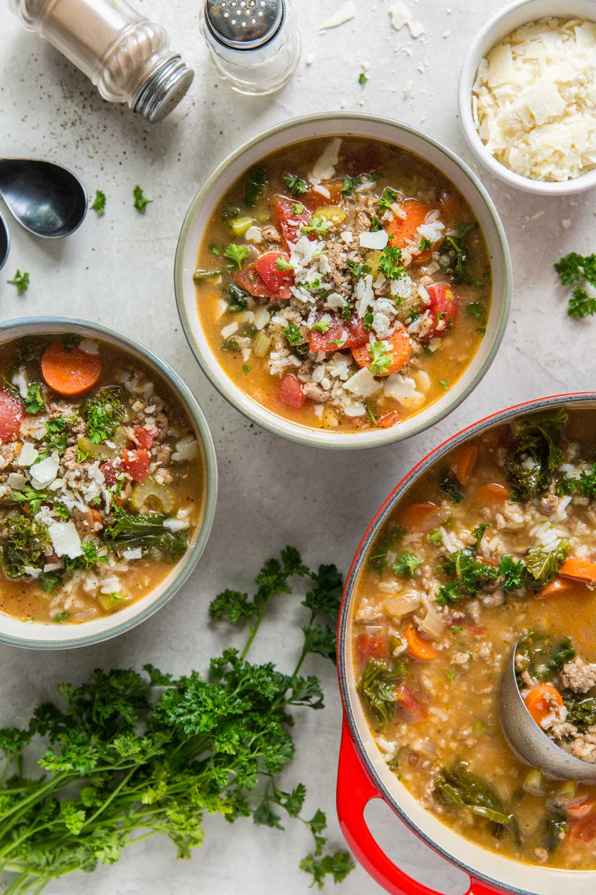 bowls of soup, pot of soup, slat and pepper shakers, parmesan cheese in a bowl